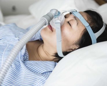 Woman wearing a CPAP device while sleeping.
