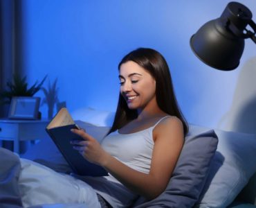 Woman reading a book in bed.