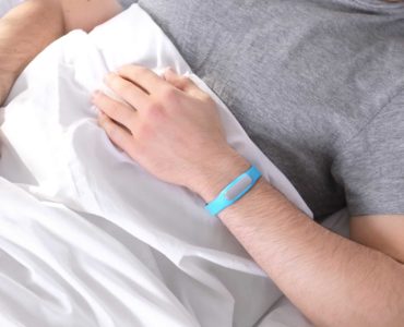 Man using sleep tracking monitor to bed